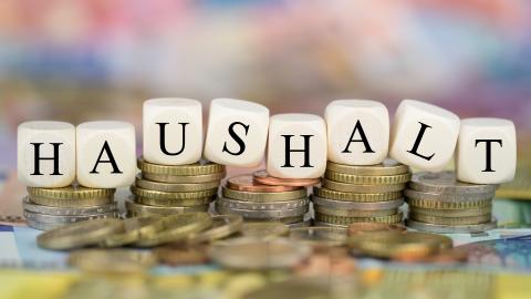 Der Haushalt ist Kernstück der Finanzplanung des Landes. Zu sehen sind Würfel mit der Aufschrift "Haushalt" und Geldmünzen.