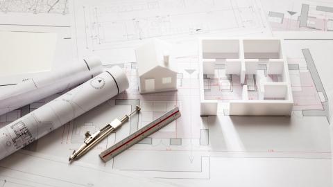 Architekturpläne, ein Modellbau, Zirkel und Stift