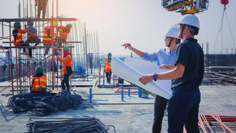 Lust auf Karriere beim LBIH? Dann könnte Ihr zukünftiger Arbeitsplatz unter anderem auch so aussehen. Eine Baustelle mit Bauarbeitern und zwei Architekten mit Bauplan, die etwas besprechen.