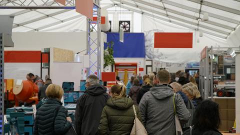 Besucherinnen und Bescuher in einer Messehalle. Besucherinnen und Bescuher in einer Messehalle.