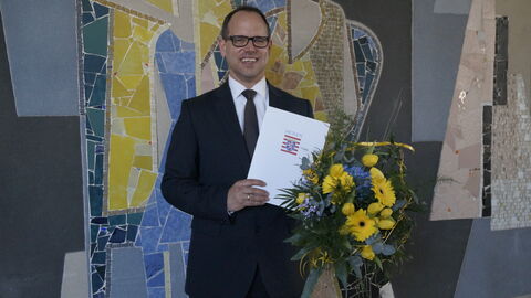 Der neue Vorsteher im Finanzamt Michelstadt, Joachim Kutzer, mit Ernennungsurkunde und Blumenpräsent.
