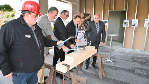 Richtfest für den Neubau des Finanzamts Nidda Werner Seipp vom Bauunternehmen Kläs GmbH, Hessens Finanzstaatssekretär Dr. Martin Worms, Niddas Bürgermeister Thorsten Eberhard, Daniel Beitlich von der Revikon GmbH sowie der Direktor des Landesbetriebs Bau und Immobilien Hessen, Thomas Platte, schlagen Nägel in einen Holzbalken.