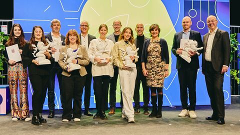 Gruppenbild der Preisverleihung mit Wirtschaftsminister Tarek Al-Wazir, Sozialstaatssekretärin Anne Janz und den Preisträgerinnen und Preisträgern. Zu sehen sind von links nach rechts: Maria Möller, Helena Kiefer, Henning Hild, Hélène Fontaine, Wirtschaftsminister Tarek Al-Wazir, Julia Dankmer, Paul Hollants, Kimia Amir-Moazami, Daniel Pulvermüller, Sozialstaatssekretärin Anne Janz, Benjamin Hein und Lutz Dietzold.