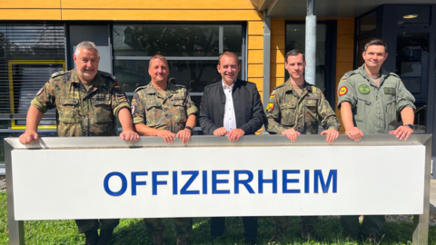 Finanzminister Lorz (Bildmitte) steht mit vier weiteren Männern in Uniformen vor einem Gebäude. Sie stehen hinter einem Schild auf dem "Offizierheim" steht.