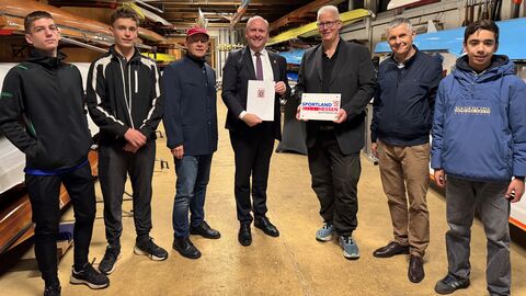 Der Erste Vorsitzende des Ruderclubs Fechenheim, Jürgen Burg (fünfter von links), freut sich mit weiteren Mitgliedern des Vereins über die Übergabe des Förderbescheids durch Hessens Finanzstaatssekretär Uwe Becker (vierter von links).  Der Erste Vorsitzende des Ruderclubs Fechenheim, Jürgen Burg, freut sich mit weiteren Mitgliedern des Vereins über die Übergabe des Förderbescheids durch Hessens Finanzstaatssekretär Uwe Becker.