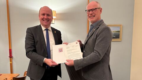 Staatssekretär Uwe Becker übergibt dem Vorsitzenden des Rudervereins, Gerd Volkmann, den Förderbescheid über 2800 Euro