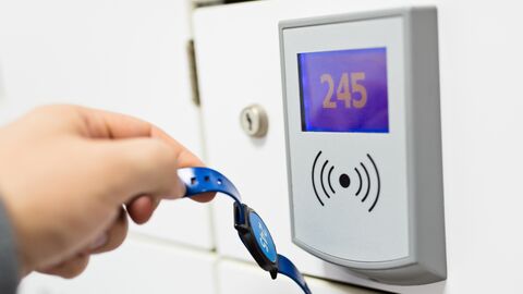 Eine Person öffnet eine Tür mithilfe eines Transponders.