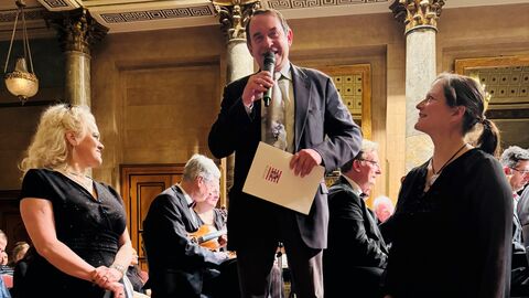 Finanzminister Professor Dr. Lorz übergibt den Förderbescheid an Claudia Grundmann (links) und Laura von Schwanenflug (rechts) vom Johann-Strauss-Orchester. 