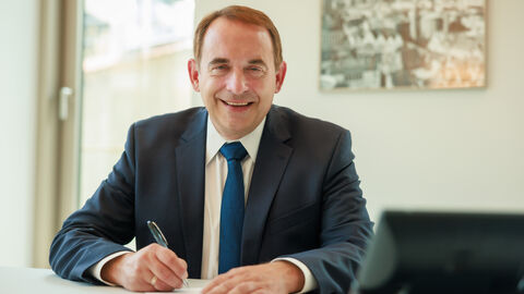 Hessens Finanzminister Professor Dr. R. Alexander Lorz unterzeichnet Unterlagen.