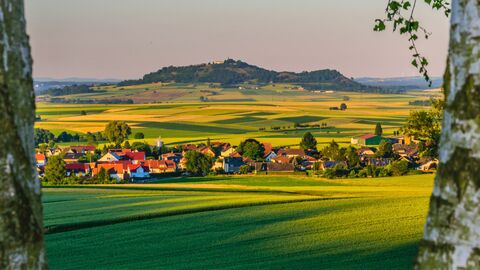 Blick auf eine Landschaft mit Feldern, Dörfern und einem Berg.
