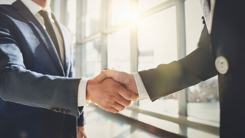 Abgemacht! Zwei Männer schütteln sich die Hände.