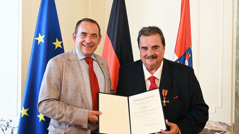Hessens Finanzminister Professor Dr. R. Alexander Lorz (links im Bild) überreicht das Bundesverdienstkreuz am Bande an Rudolf-Lothar Glas aus Wiesbaden (rechts). 