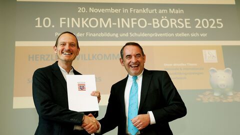 Der Vorsitzende des Präventionsnetzwerks Finanzkompetenz, Nicolas Mantseris, nimmt den Förderbescheid von Finanzminister Lorz entgegen.