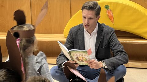 Mann liest Kindern etwas vor. 